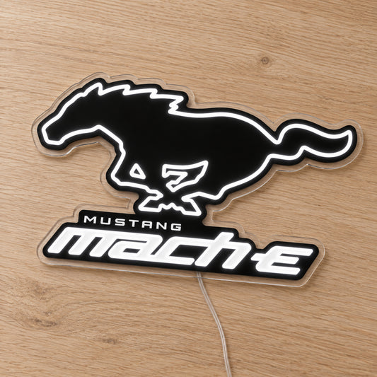 Ford Mustang Mach-E LED Neon Sign in white, featuring a Mustang horse and Mach-E lettering on a wooden surface.