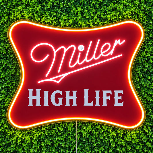 Miller High Life LED Neon Sign, featuring illuminated beer-brand logo on a green foliage wall.