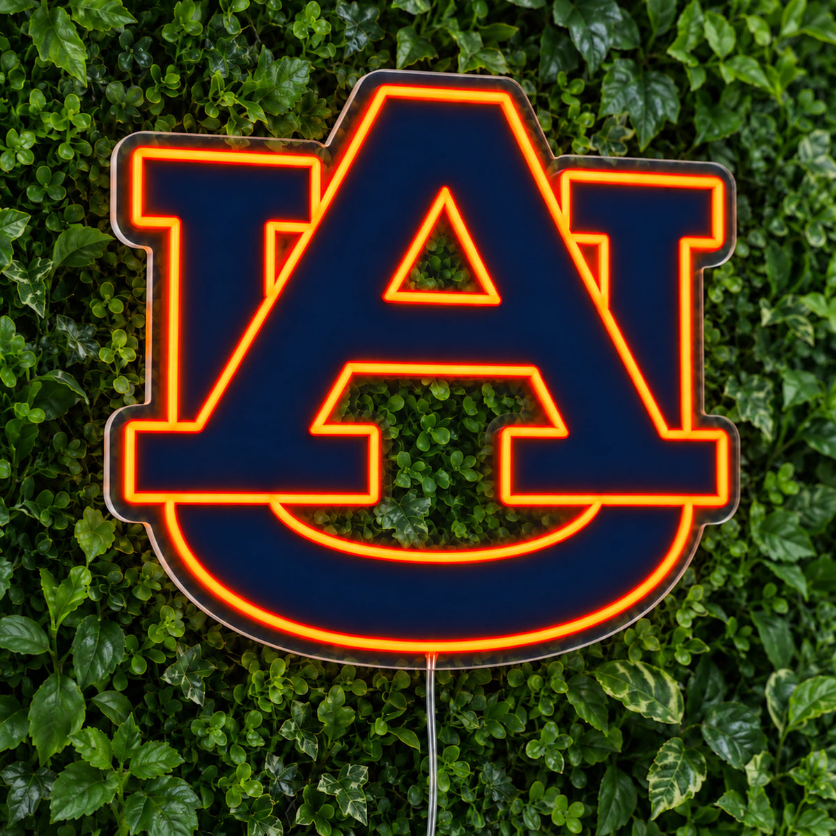 Auburn Tigers LED Neon Sign, featuring team logo displayed on a green foliage wall.
