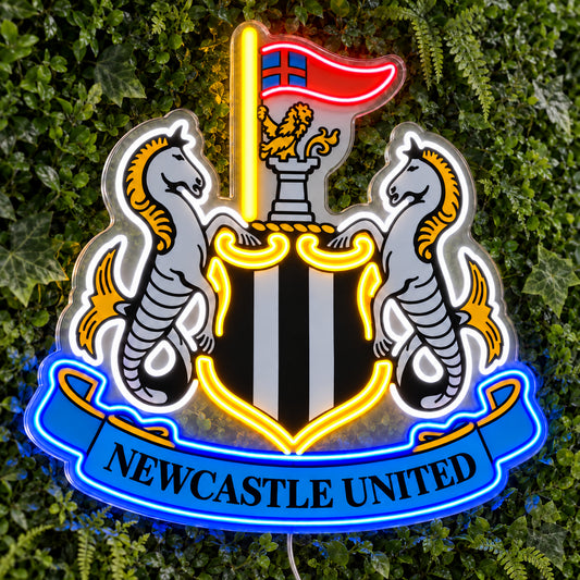 Newcastle United LED Neon Sign, featuring team logo displayed on a green foliage wall.