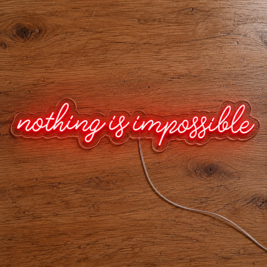 Nothing Is Impossible Big LED Neon Sign in red, featuring single line of script lettering on a wooden surface.