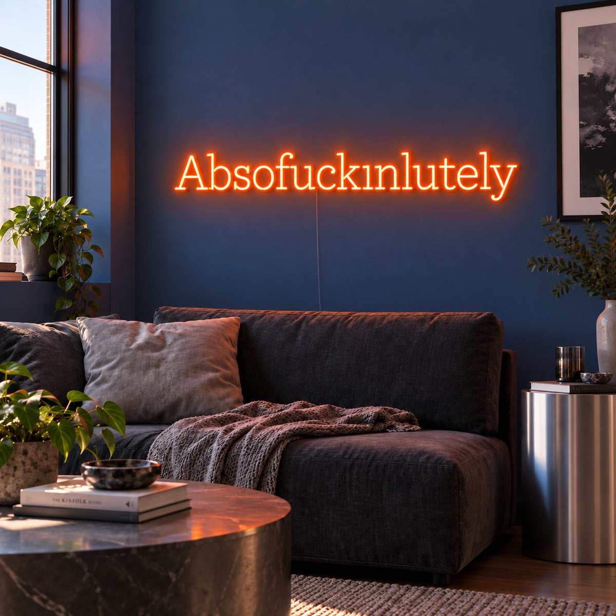 Orange version of the Absofuckinlutely Neon Sign, shown above a charcoal sofa on a blue wall.