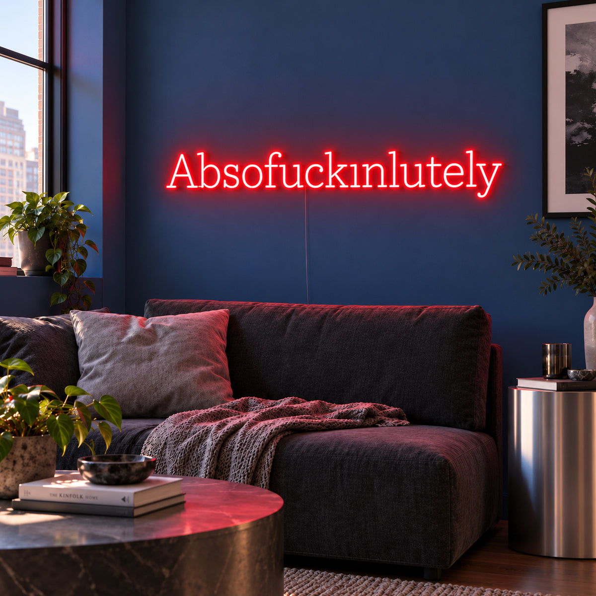 Absofuckinlutely Neon Sign with red lighting, displayed above a charcoal sofa on a blue wall.