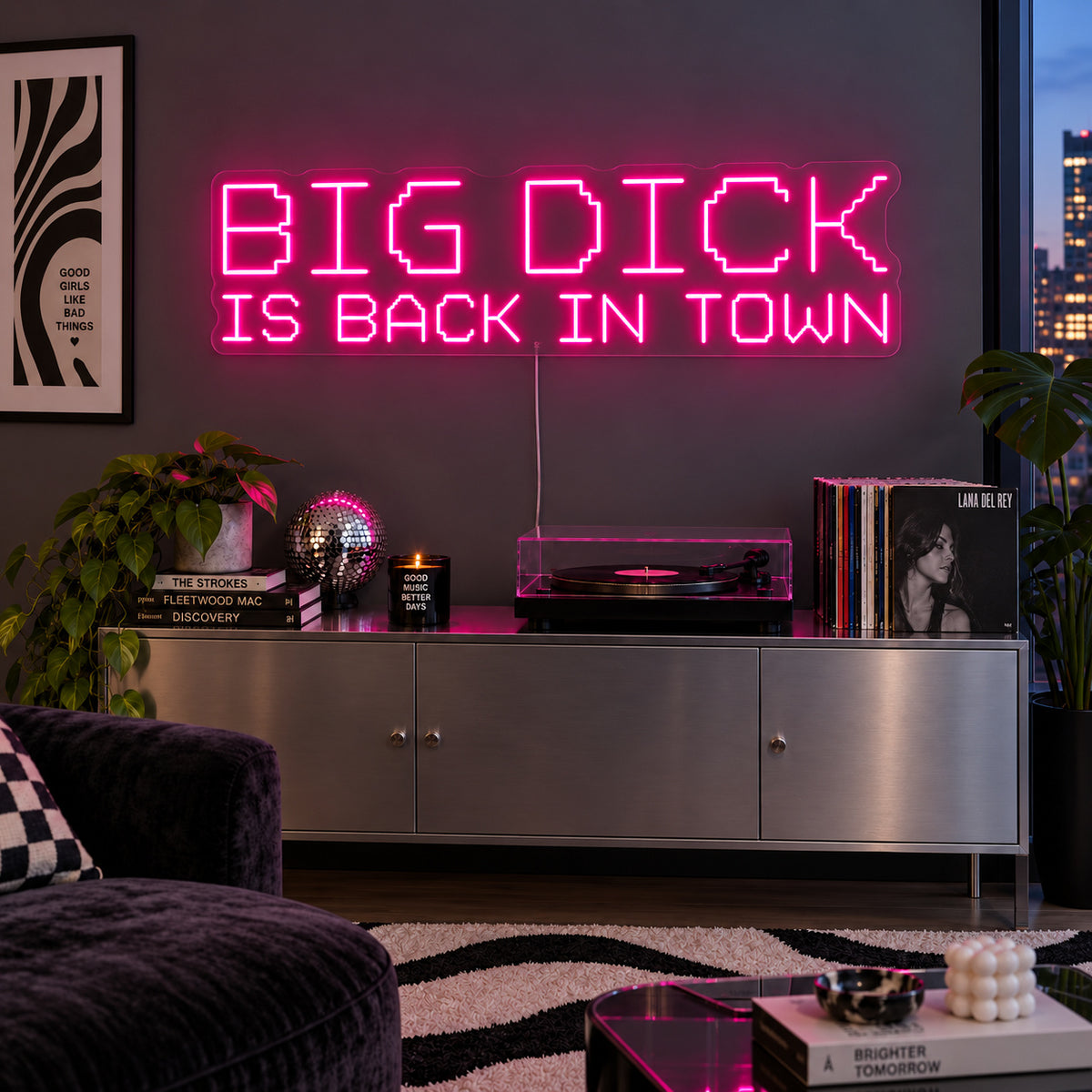 Rose Red version of the Big Dick Is Back In Town Neon Sign, shown above a record player and metal sideboard.