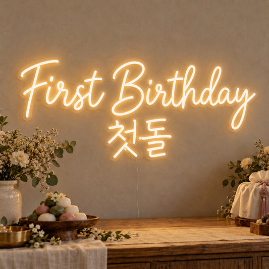 First Birthday English & Korean Neon Sign on clear cut-to-shape acrylic, illuminated on a wall in a styled celebration setting