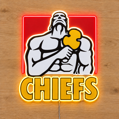 Chiefs neon sign with a three-sided red neon frame, white warrior outline and yellow lettering on wood, overhead view