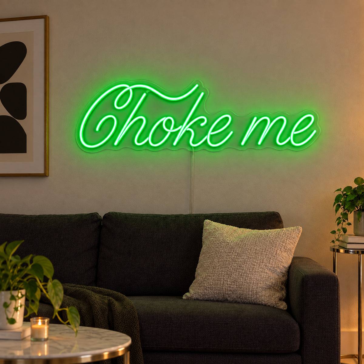Choke Me Neon Sign with green lighting, displayed above a charcoal sofa.