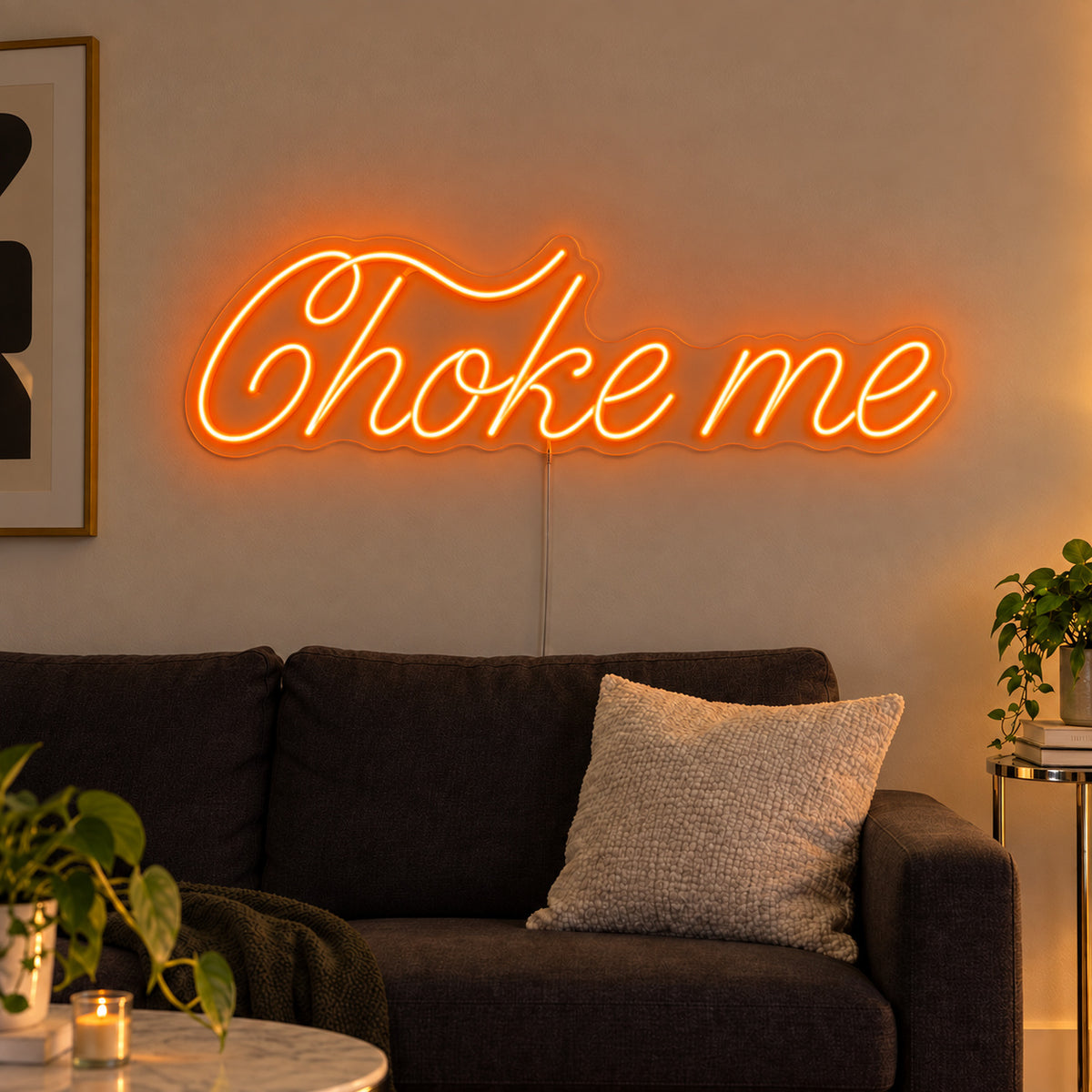 Orange version of the Choke Me Neon Sign, shown above a charcoal sofa.