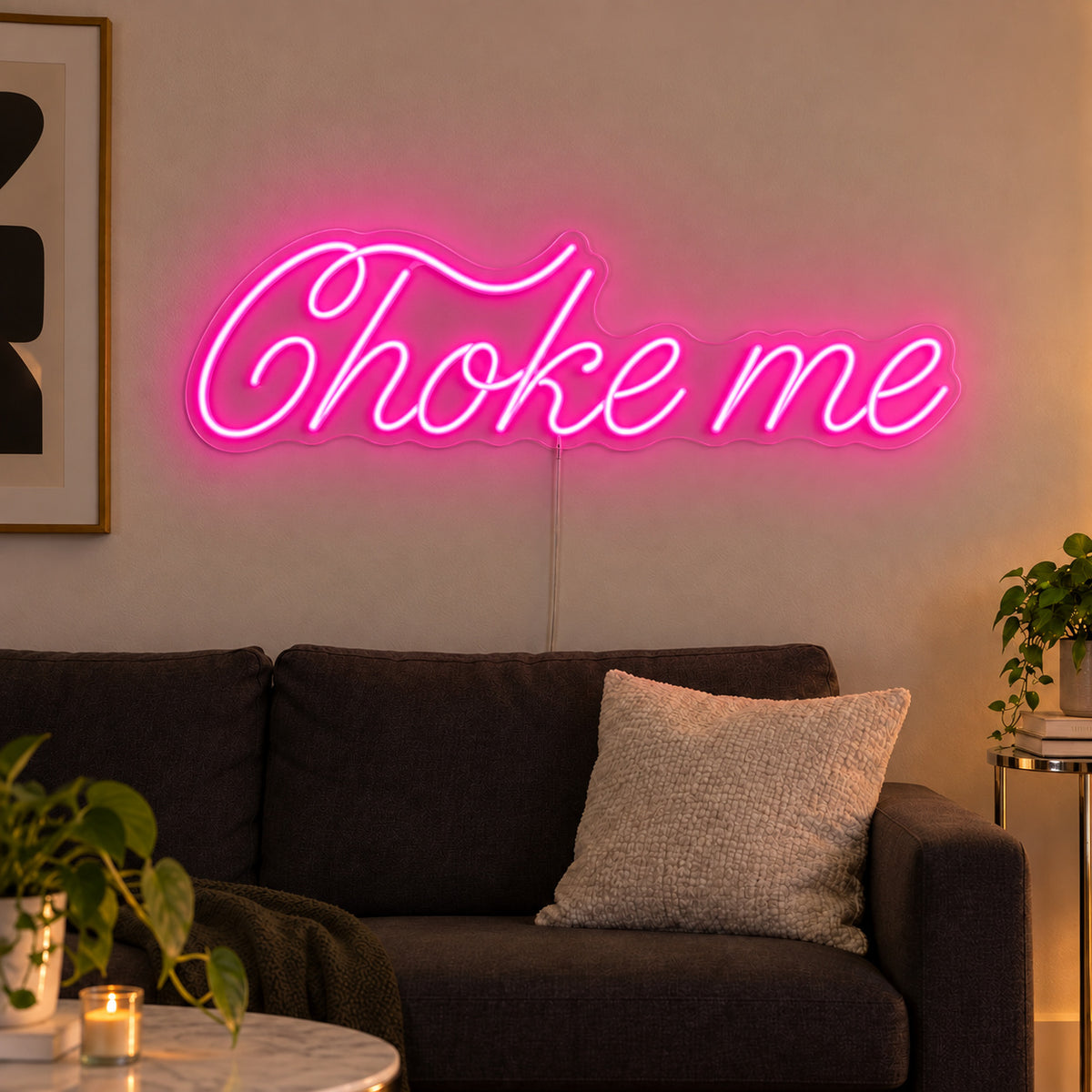 Choke Me Neon Sign glowing pink above a charcoal sofa.