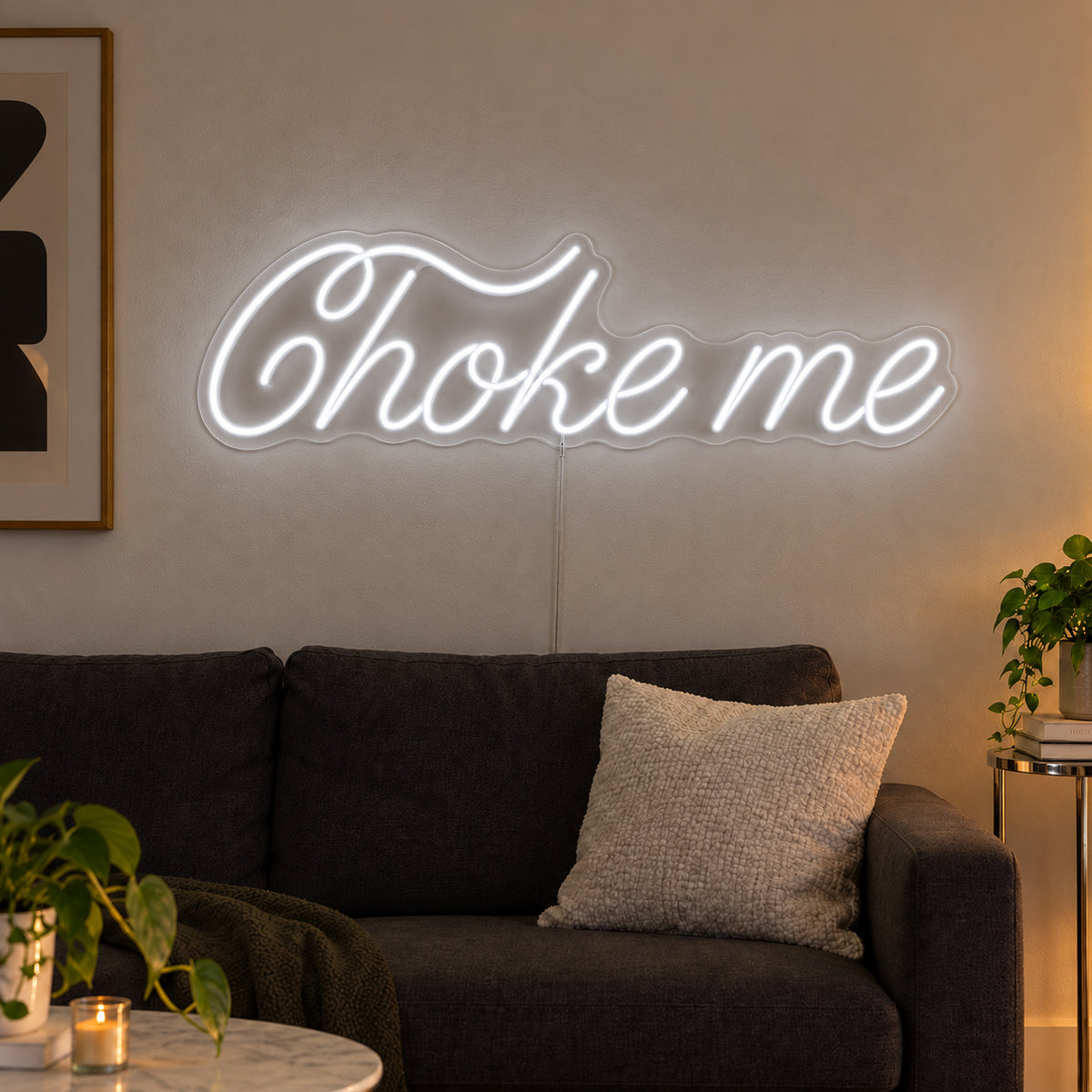 Choke Me Neon Sign glowing white above a charcoal sofa.