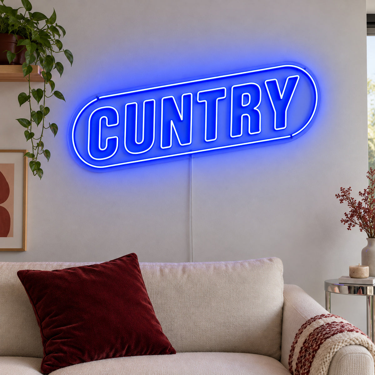 Cuntry Neon Sign glowing blue inside a rounded border above a cream sofa.