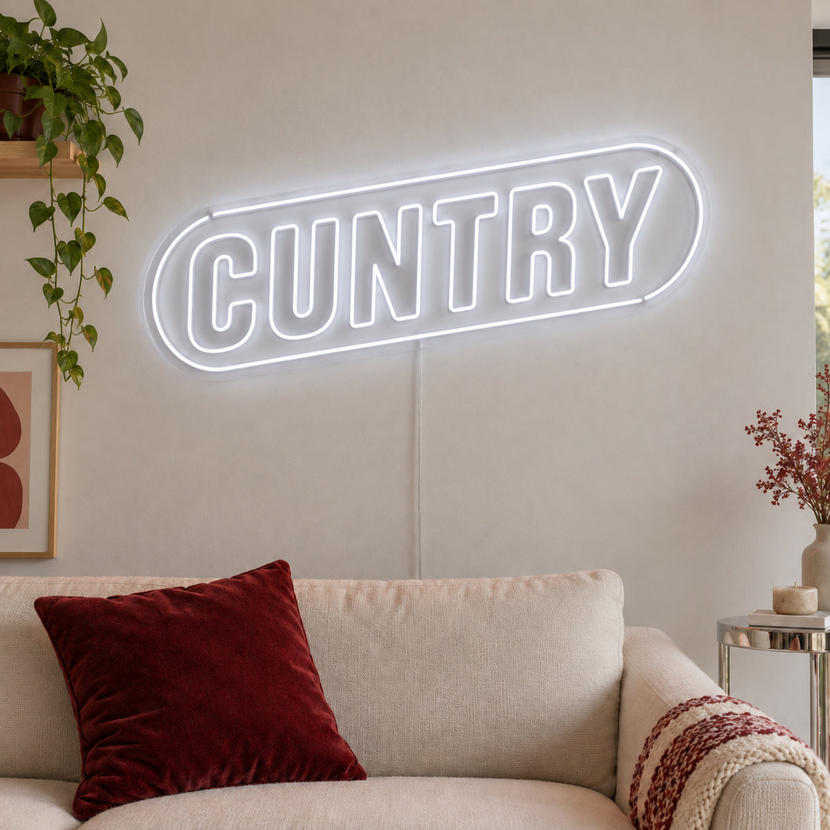 Cuntry Neon Sign, RGB colour-changing option shown in white inside a rounded border above a cream sofa.