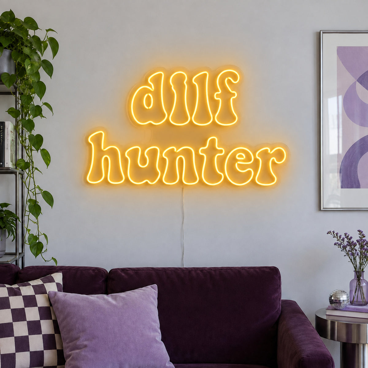 DILF Hunter Neon Sign glowing gold above a sofa with purple cushions.