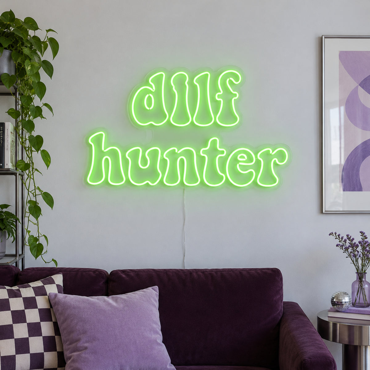 DILF Hunter Neon Sign in green above a sofa with purple cushions.