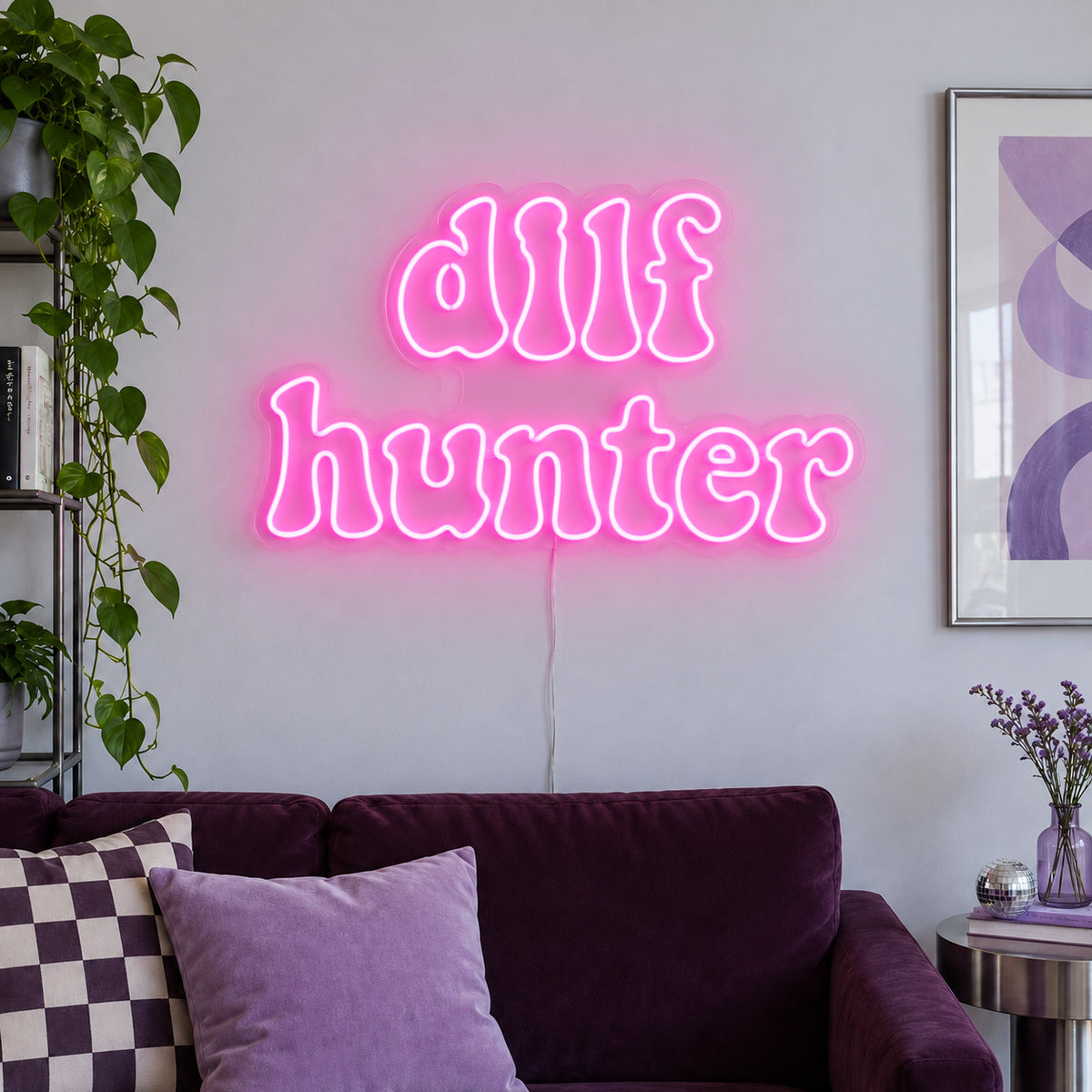 DILF Hunter Neon Sign glowing pink above a sofa with purple cushions.