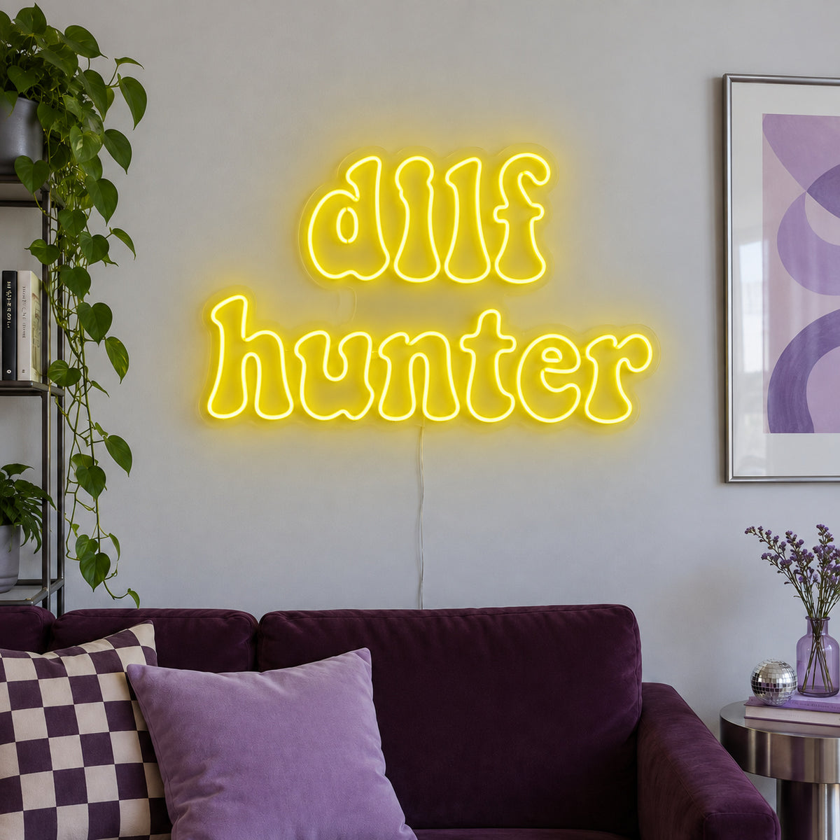 DILF Hunter Neon Sign with yellow lighting, displayed above a sofa with purple cushions.
