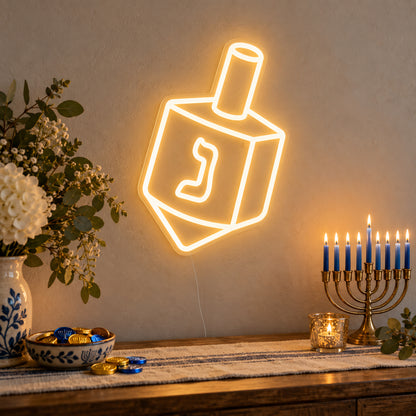 Dreidel Neon Sign on clear cut-to-shape acrylic, illuminated on a wall in a styled celebration setting