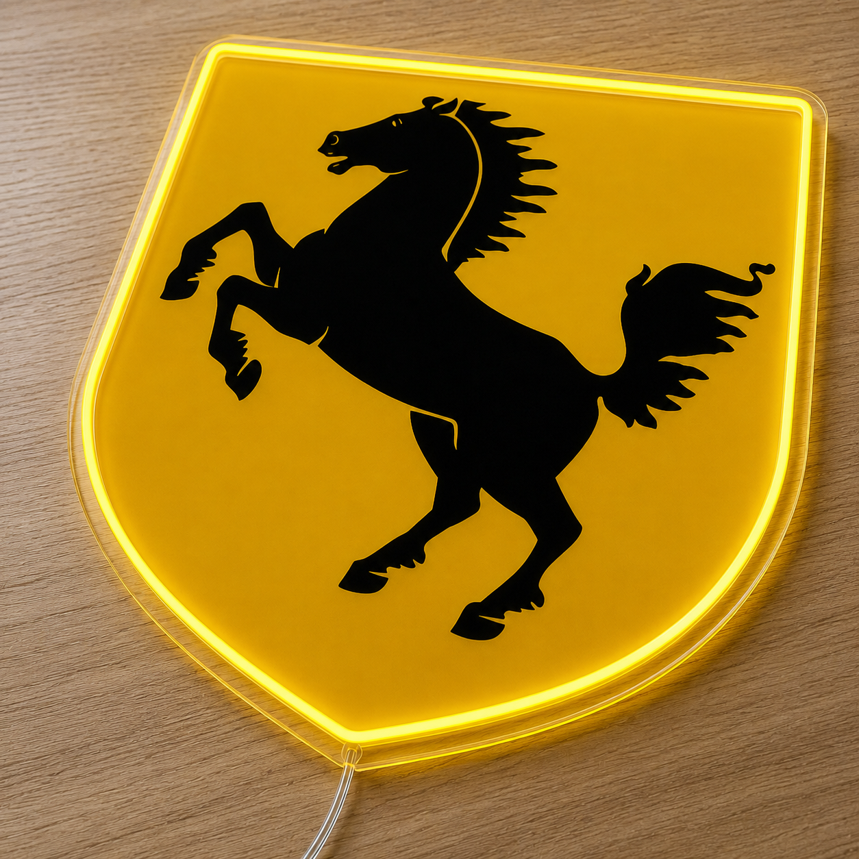 Angled view of Ferrari shield neon sign glowing yellow on a wood surface