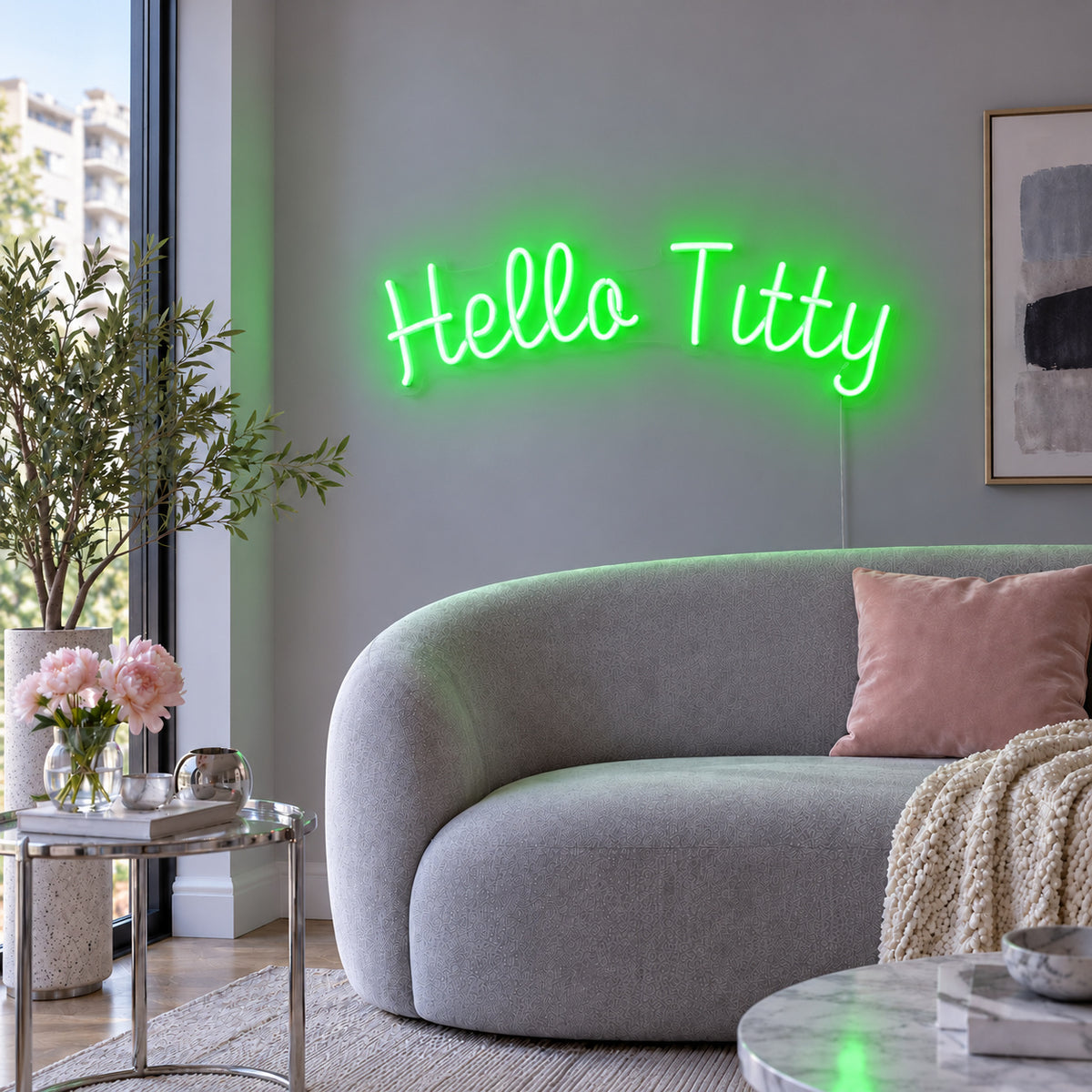 Hello Titty Neon Sign with green lighting, displayed above a curved grey sofa.