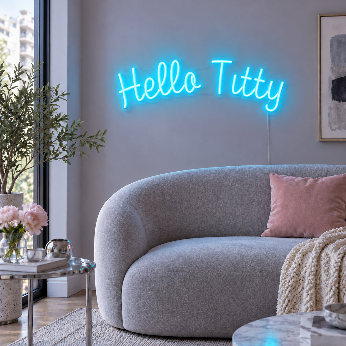 Ice Blue version of the Hello Titty Neon Sign, shown above a curved grey sofa.