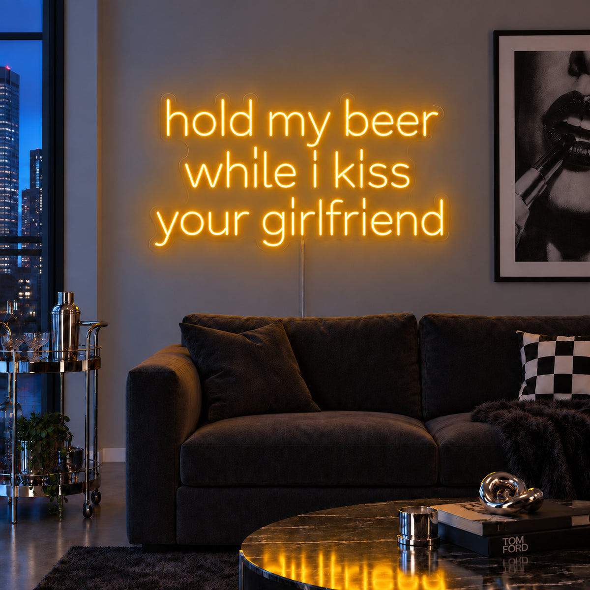 Hold My Beer While I Kiss Your Girlfriend Neon Sign glowing gold above a burgundy sofa.