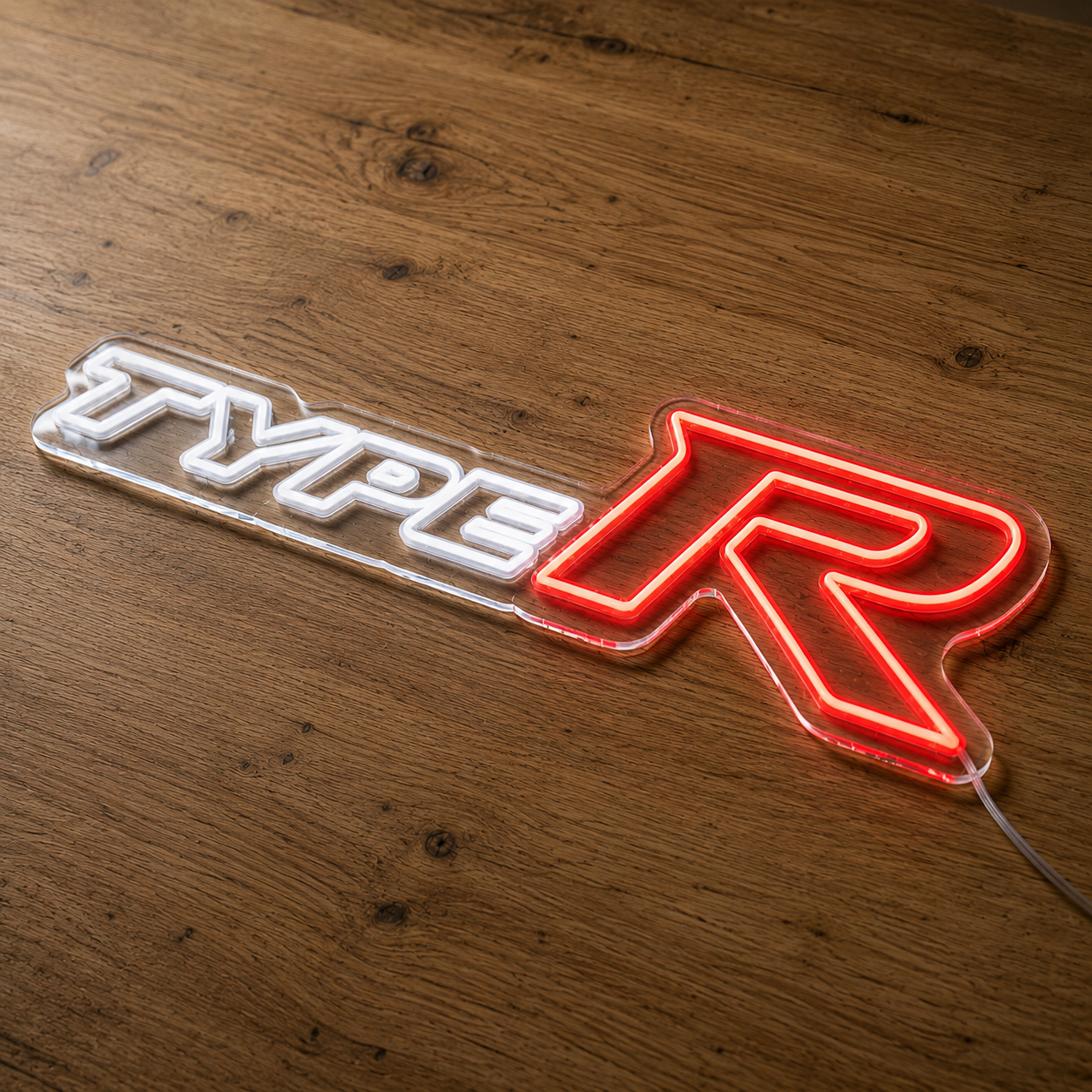 Angled view of Honda Type R neon sign with glowing red R on a wood surface
