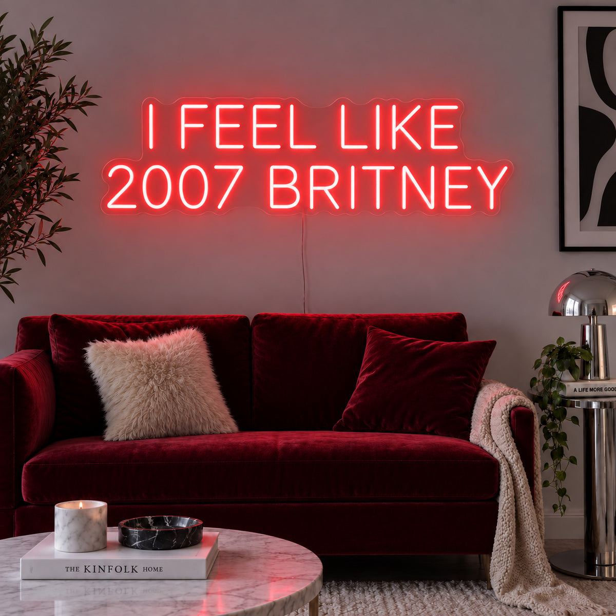 I Feel Like 2007 Britney Neon Sign with red lighting, displayed above a burgundy sofa.