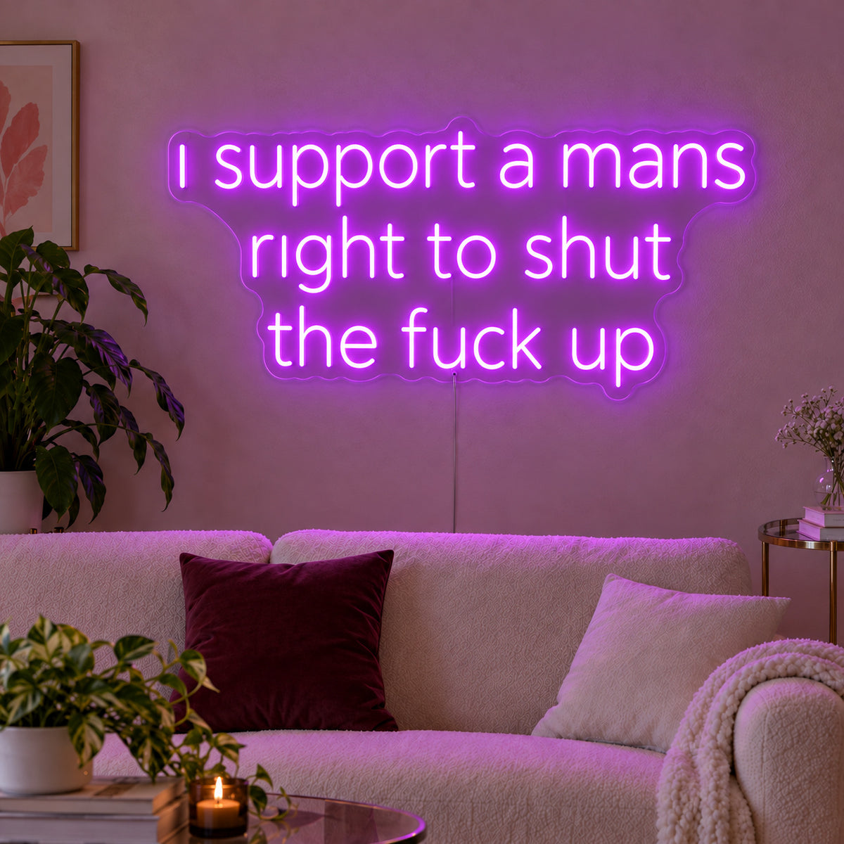 I Support A Mans Right To Shut The Fuck Up Neon Sign with purple lighting, displayed above a cream sofa.