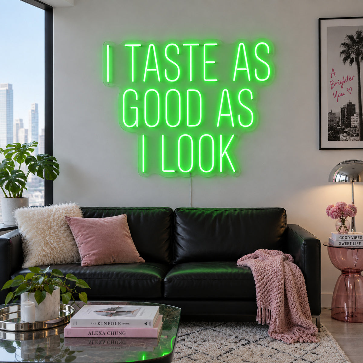 I Taste As Good As I Look Neon Sign with green lighting, displayed above a black sofa.