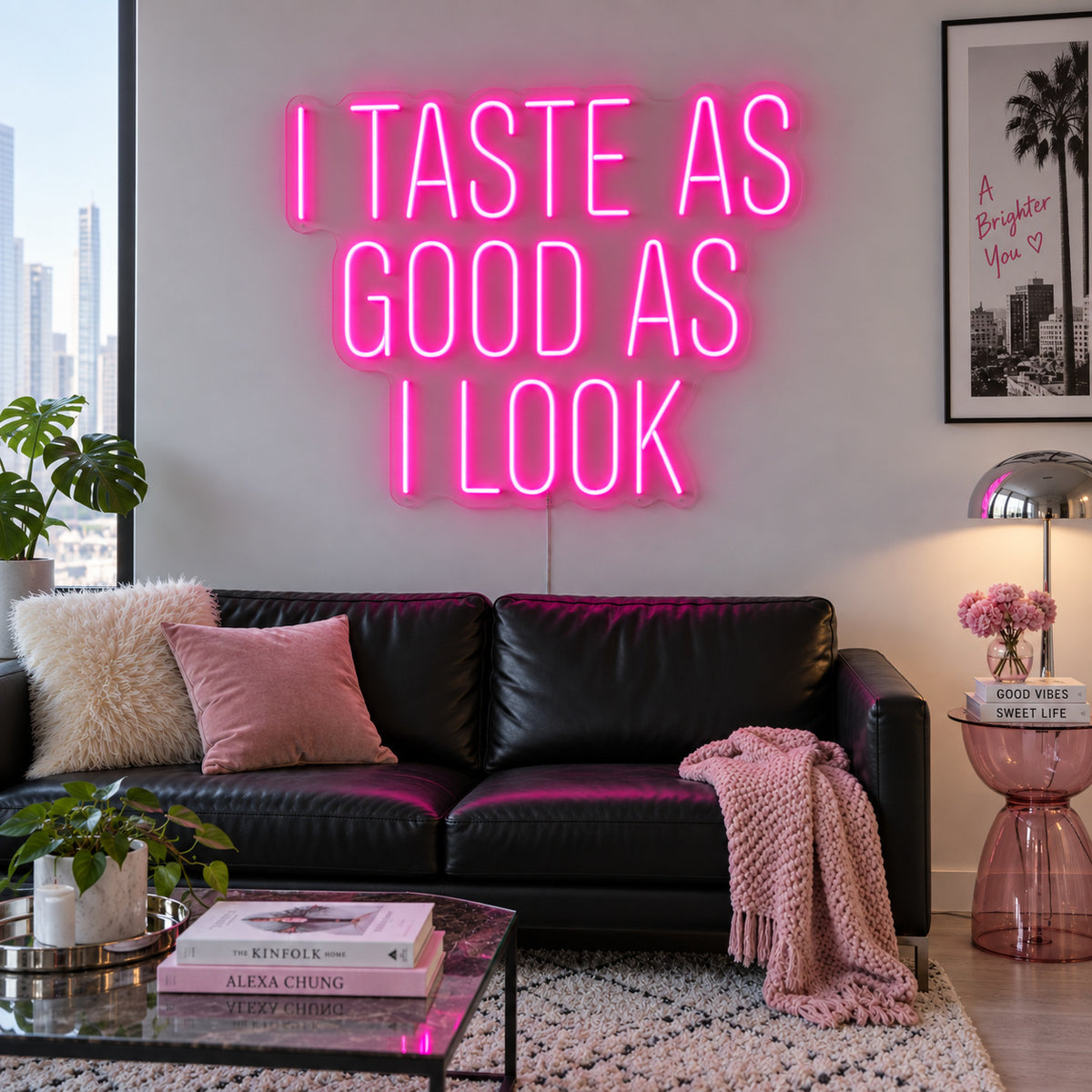 Rose Red version of the I Taste As Good As I Look Neon Sign, shown above a black sofa.