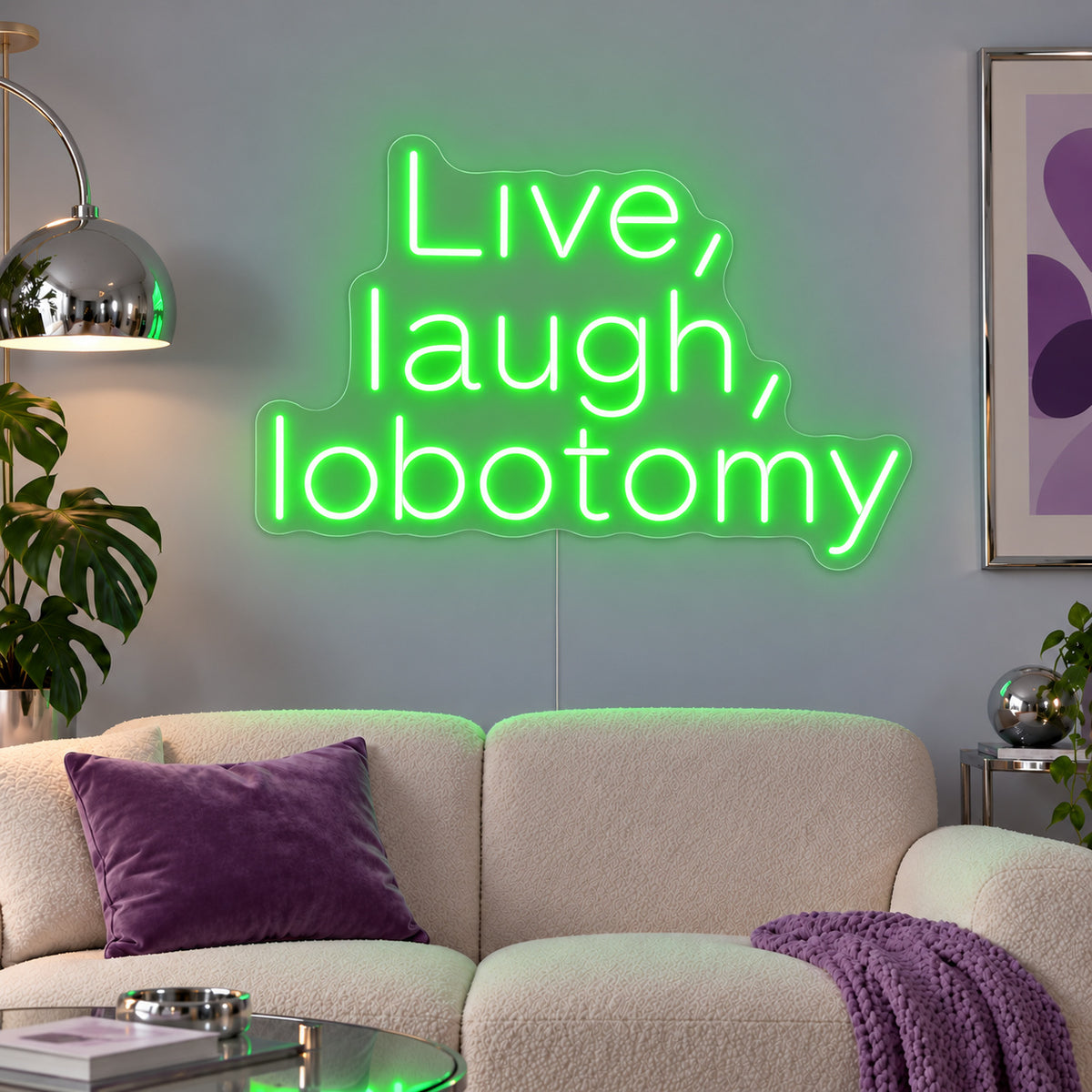 Live, Laugh, Lobotomy Neon Sign with green lighting, displayed above a cream sofa with purple cushions.