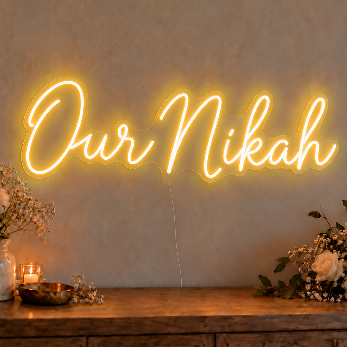 Our Nikah Neon Sign in gold LED neon on clear acrylic, angled view