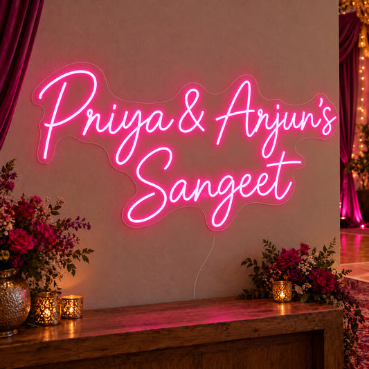 Personalised Sangeet Neon Sign on clear cut-to-shape acrylic, illuminated on a wall in a styled celebration setting; sample personalised wording shown