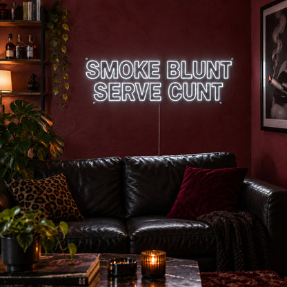 Smoke Blunt Serve Cunt Neon Sign, RGB colour-changing option shown in white above a black leather sofa.