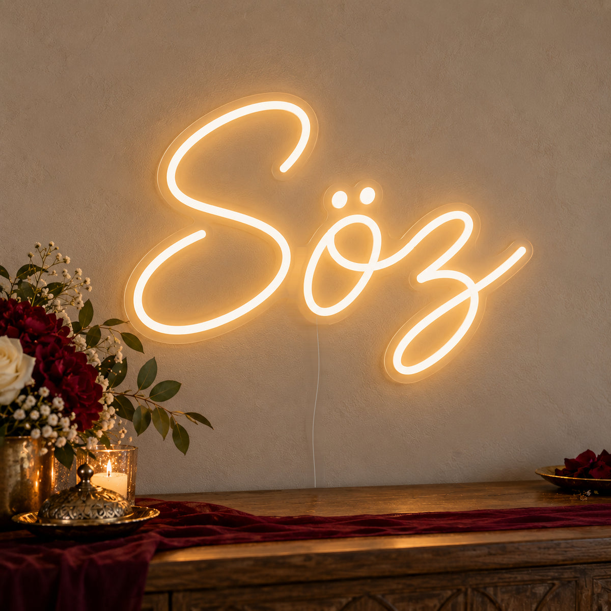 Söz Neon Sign on clear cut-to-shape acrylic, illuminated on a wall in a styled celebration setting