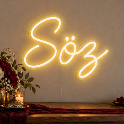 Söz Neon Sign in gold LED neon on clear acrylic, angled view