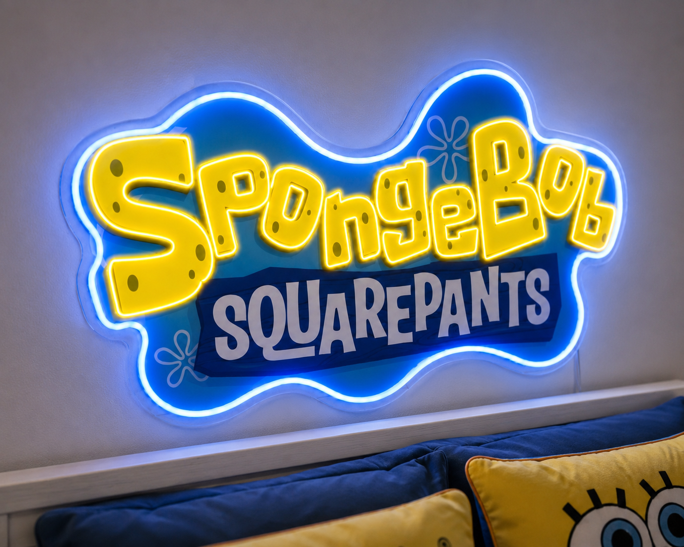 SpongeBob SquarePants neon light sign mounted on a wall above a bed