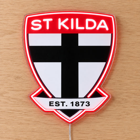 St Kilda Saints Neon Sign with white neon lettering and red outline, lying flat on light wood
