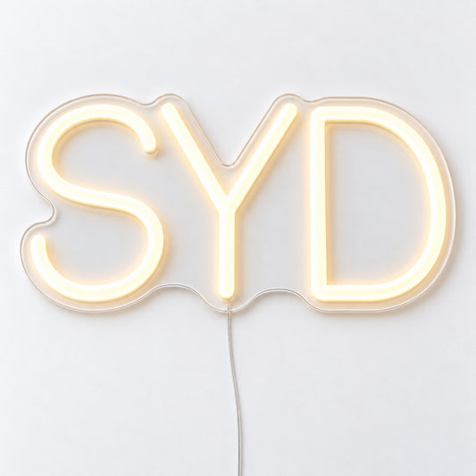SYD Airport Code Neon Sign, featuring the SYD airport code in clean LED neon lettering, on a single clear acrylic backing displayed on a white surface.