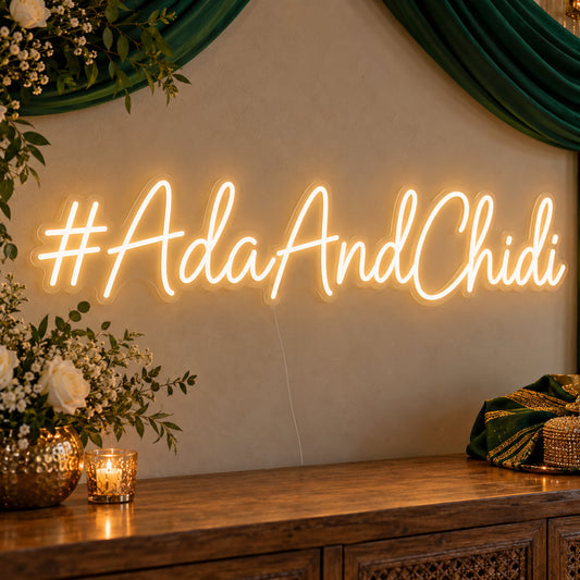 Personalised Wedding Hashtag Neon Sign on clear cut-to-shape acrylic in an illuminated wall display; example personalisation shown.