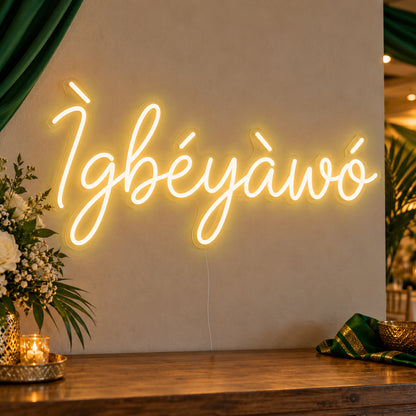 Ìgbéyàwó Yoruba Wedding Neon Sign in gold LED neon on clear acrylic, angled view