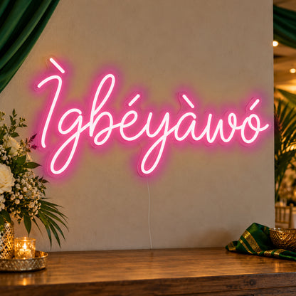 Ìgbéyàwó Yoruba Wedding Neon Sign in rose red LED neon on clear acrylic, angled view